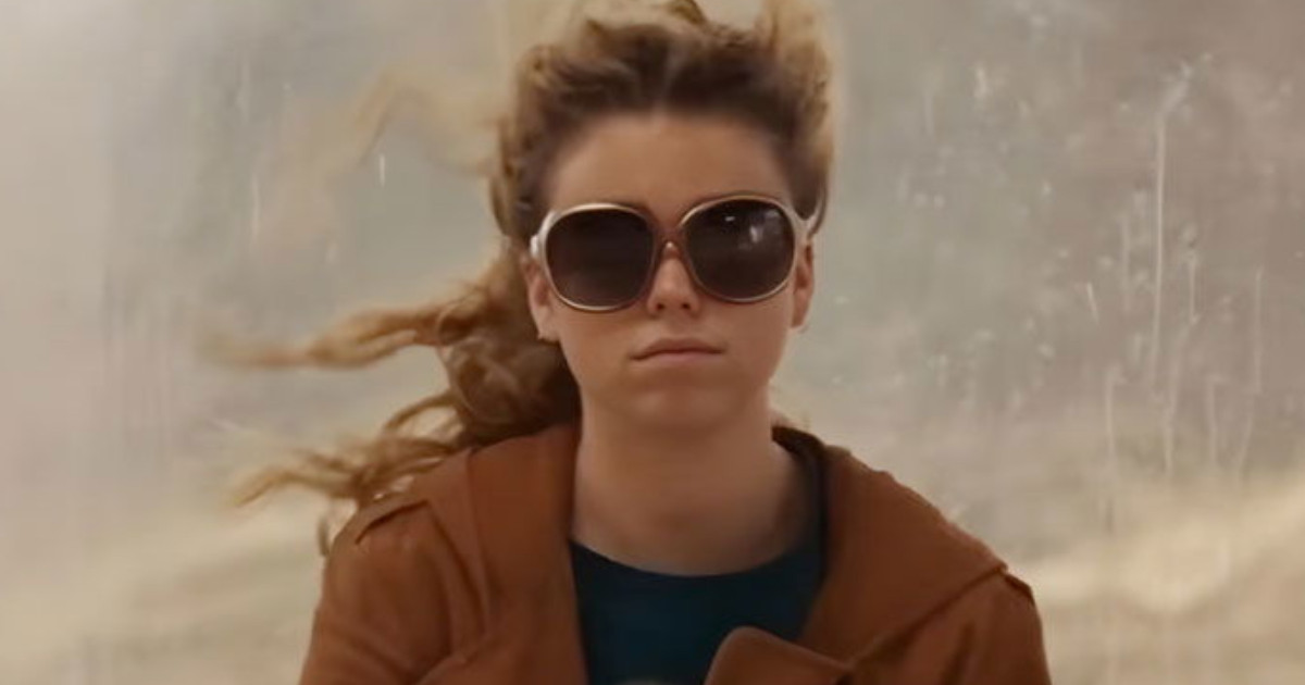 A leharcolt, kócos Milly Alcock egy buszmegállóban várakozik a Supergirl első kedvcsinálójában 