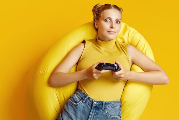 portrait-gorgeous-happy-blonde-gamer-girl-with-joystick-lying-sack-chair-yellow-background-1.jpg